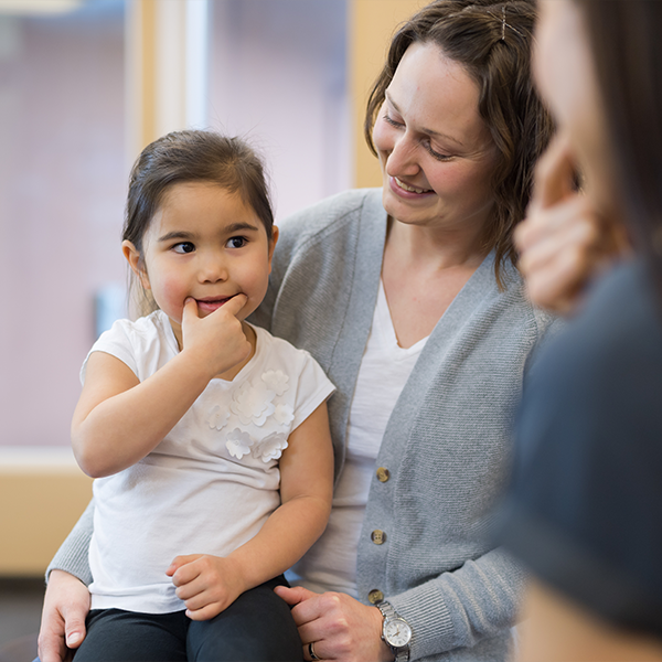 Kindje op de schoot van haar mama bij de logopediste